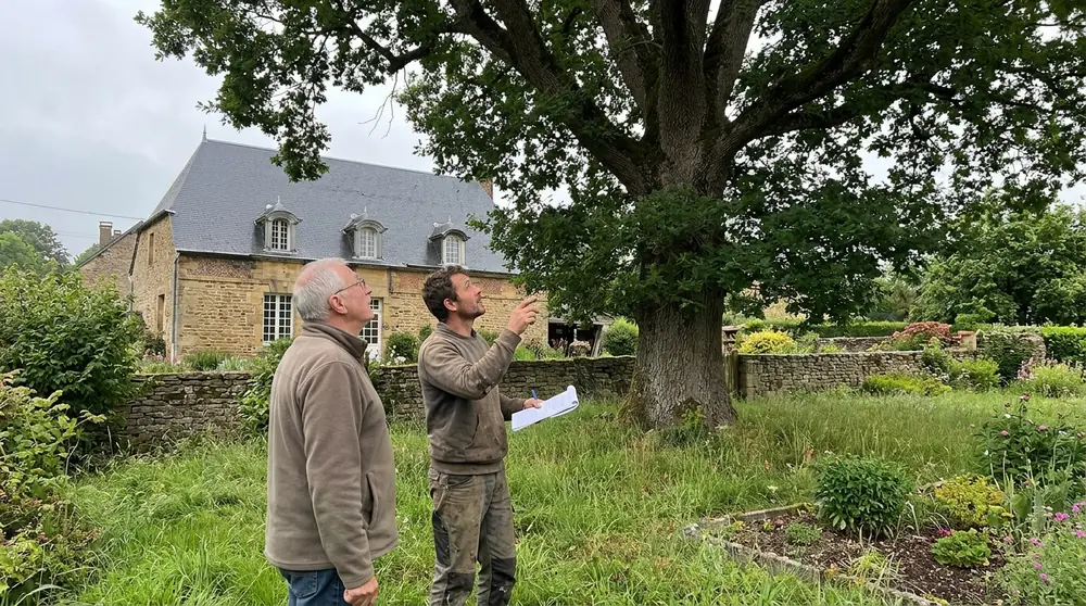 L'artisan montre au propriétaire les branches à retirer
